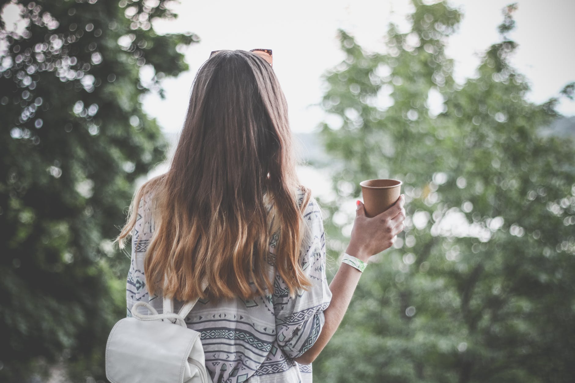 woman holding brown paper cup